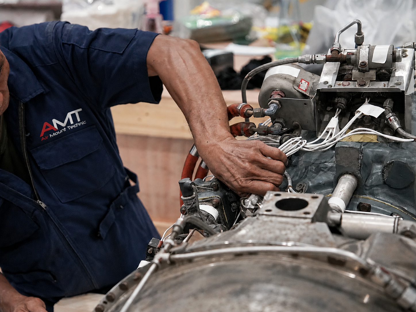 AMT technician in a navy Air Mount Technic shirt working on hydraulic and brake components
